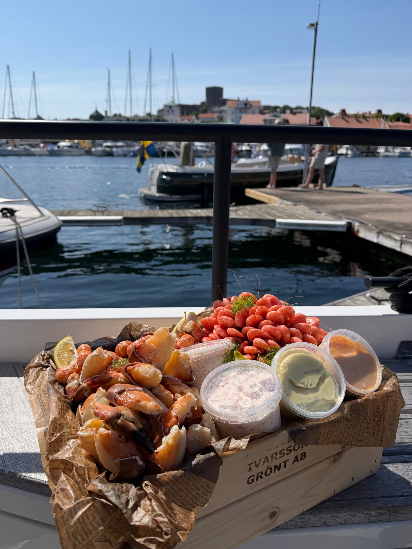 Skaldjurslåda med krabbklor, räkor och såser i Marstrands hamn