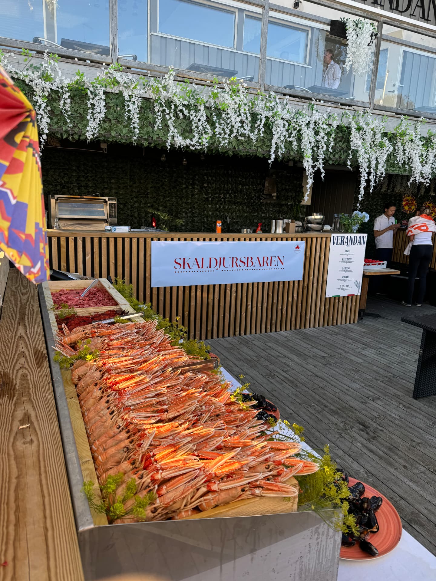 Skaldjursbaren med långbord av havskräftor på en uteservering